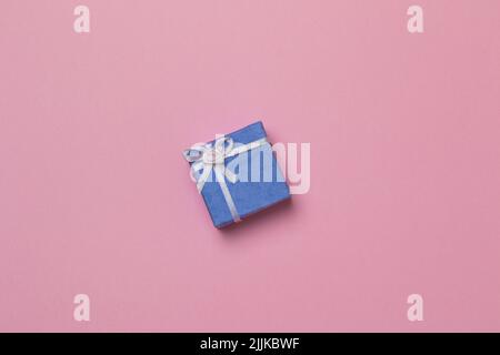 A small purple gift box isolated in the pink background Stock Photo