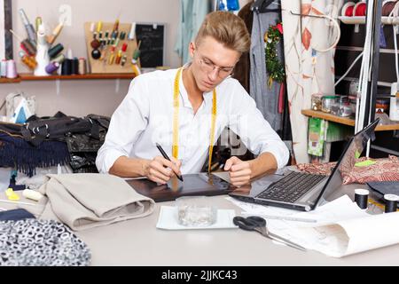 Tailor creating pattern using laptop Stock Photo