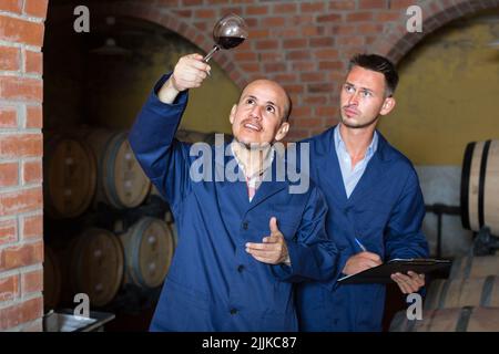 two men holding glass of wine Stock Photo