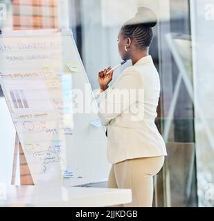 My neurons are firing at full speed. a young businessman preparing for a presentation while working on a whiteboard. Stock Photo