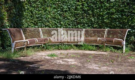 Rusty metal benches in a circle without people in a park. There are no trademarks in the shot. Stock Photo