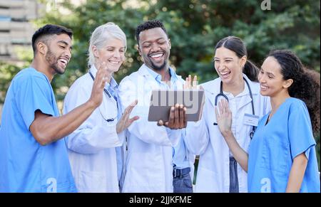 Now we can all attend the seminar. a group of doctors using a digital tablet against a city background. Stock Photo