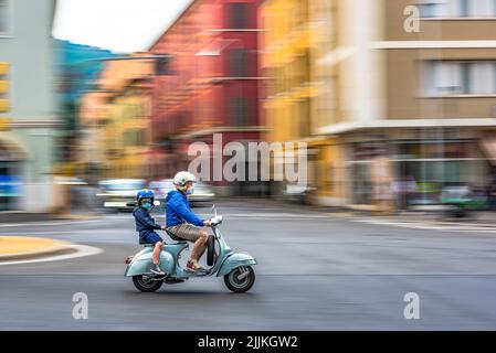 A Vespa scooter goes fast in the city, in times of pandemic Stock Photo