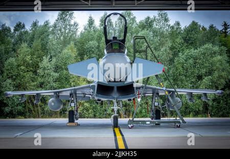 Laage, Germany. 27th July, 2022. A Eurofighter stands in a hangar at the air base where it flies toward Estonia. A total of four fighter aircraft are to be deployed as part of NATO's long-standing mission to provide air security for the Baltic states on the eastern flank of the military alliance. The aircraft from Tactical Air Wing 71 'Richthofen' are to fly missions from Ämari (Estonia) in the coming weeks. Credit: Jens Büttner/dpa/Alamy Live News Stock Photo