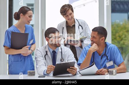 Working on healthcare matters with utmost dedication. a group of medical practitioners working together in a hospital boardroom. Stock Photo