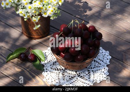 sweet cherries on wooden table in the garden Stock Photo