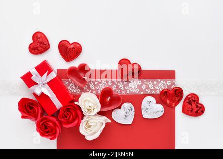 Heart of red ribbon and a border of red roses on a dark rustic ...