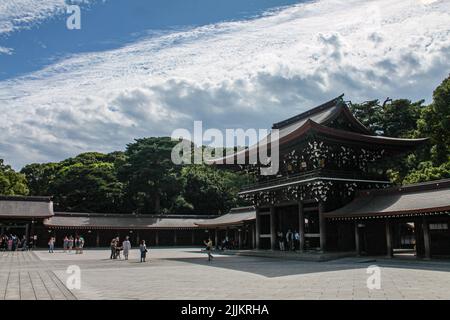 The Meji Jingu shrine in Tokyo, Japan with lush trees surrounding it under a sea of clouds on a sunny day Stock Photo