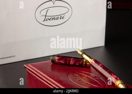A close-up shot of a red fountain pen with a golden nib on its box Stock Photo