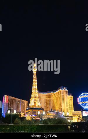 A vertical night shot of the Eiffel Tower in front of the Paris Hotel and Casino in Las Vegas Stock Photo