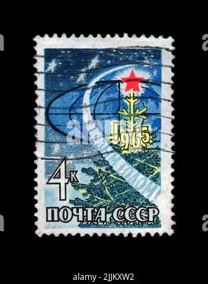 New Year Tree with bright red star, USSR, circa 1964. Happy New Year 1965as text. vintage post stamp isolated on black background. Stock Photo
