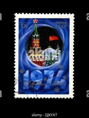 Kremlin tower with red star, red USSR flag, fir-tree, snow for New Year, USSR, circa 1973. Happy New Year 1974 as text. Stock Photo