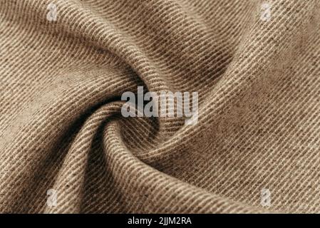 Texture of twisted dense material of brown color. Piece of fabric with waves for tailoring Stock Photo
