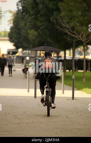 A vertical back view of a biker in an urban environment, Frankfurt, Germany Stock Photo