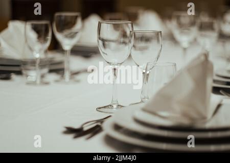 A closeup shot of an elegantly folded napkin and arranged glasses on a dinner table Stock Photo