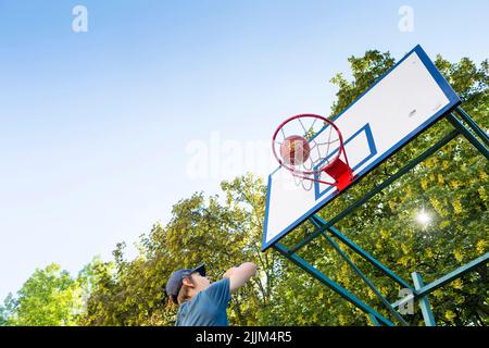 boy playing basketball outdoor Stock Photo