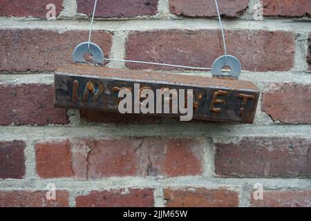 An old sign of Internet hanging from a brick wall Stock Photo