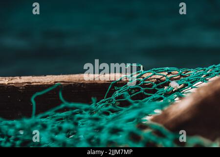 The close-up shot of a turquoise  net on a wooden box Stock Photo