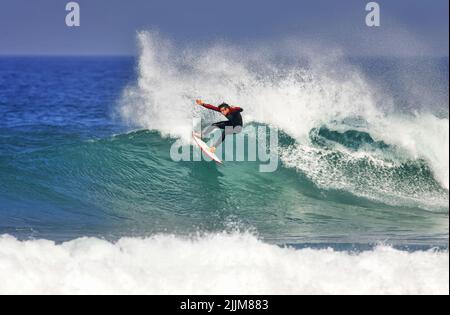 A surfer executing a cutback on a wave in Watergate Bay Stock Photo