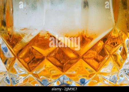 Crystal glass filled with whiskey and ice Stock Photo