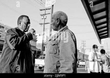 A shallow focus of two African American men catching up on the streets of downtown Los angeles, California Stock Photo