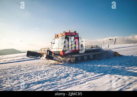 A snow groomer making fresh tracks for ski alpinism enthusiasts in ski resort Plese near Podkonice Stock Photo
