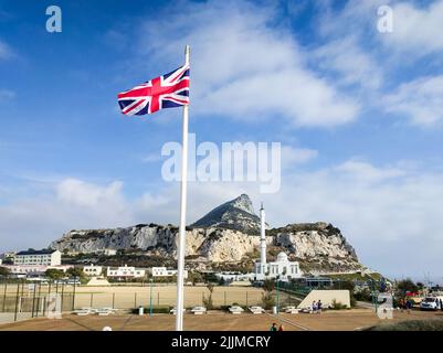 A beautiful shot of a UK flag and King Fahad bin Abdulaziz Al-Saud Mosque in the background Stock Photo