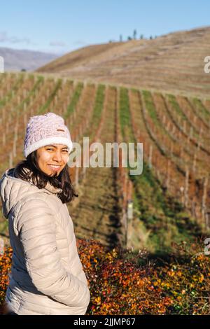 A vertical shot of a Hispanic smiling female in the field in autumn Stock Photo