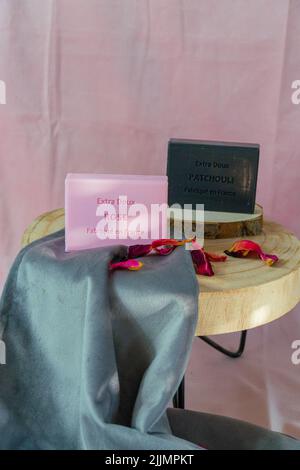 A vertical shot of rose and patchouli scented square soaps on a gray velvet sheet Stock Photo