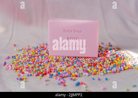 A closeup shot of rose-scented square soap on colorful small balls Stock Photo