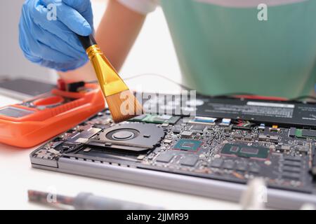 Maintenance laptop engineer holding dust brush closeup Stock Photo