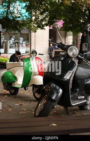 A vertical closeup of two old motorcycles parked on the street in Warsaw. Stock Photo