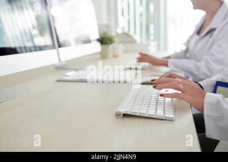 Closeup image of scientists working on computers in research center when creating new vaccine or medicine Stock Photo