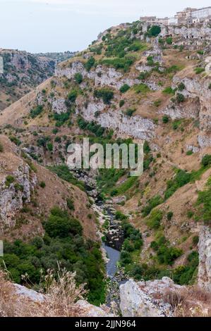 A beautiful high angle of a river under high gorges the city of Matera Stock Photo
