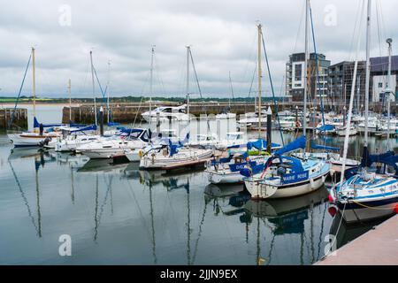 CAERNARFON, WALES - JULY 08, 2022: Boats and yachts moored in Victoria Dock in Caernarfon, a royal town, community and port in Gwynedd, Wales Stock Photo