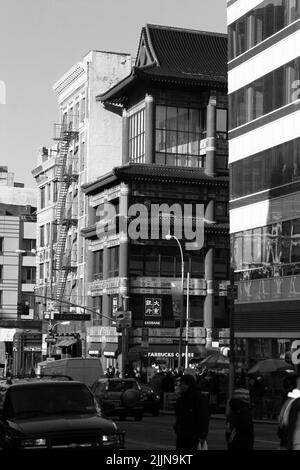 A vertical shot of buildings and crowded streets in New York City, USA in grayscale Stock Photo