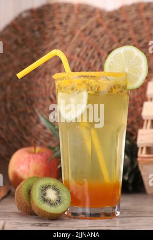 A still life with a refreshing passion fruit-flavored soda decorated with lemon, kiwi, and apple Stock Photo