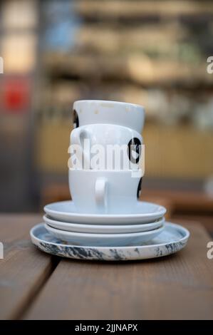A shallow focus of a stack of empty coffee cups on terras on a wooden table with blurred background Stock Photo