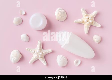 Roll on deodorant antiperspirant, sea stars and shells over pastel pink background. Sea minerals toiletries and cosmetics for body care. Toiletries. Stock Photo