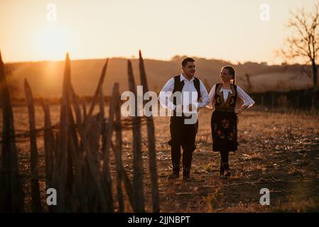 A close-up shot of a young Serbian couple in traditional costume in the field Stock Photo
