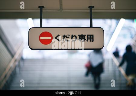 Sign reading 'kudari senmon' (down only) on steps in a Japanese subway system. Stock Photo