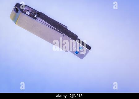 A closeup of a USB stick isolated on a blue background with copyspace Stock Photo