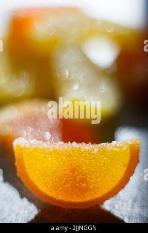 A vertical closeup shot of sweet marmalade sliced like orange and lemon on the blurry background Stock Photo