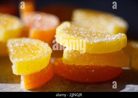 A closeup shot of sweet marmalades sliced like orange and lemon on the blurry background Stock Photo
