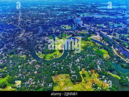 An aerial view of the flowing Karnaphuli River surrounded by greens in Bangladesh Stock Photo