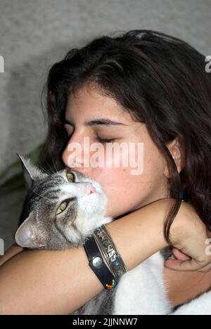 Teenage girl cuddling her pet cat Stock Photo