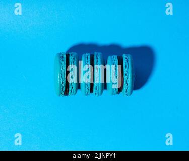 A top view of three macaroons isolated on blue background Stock Photo