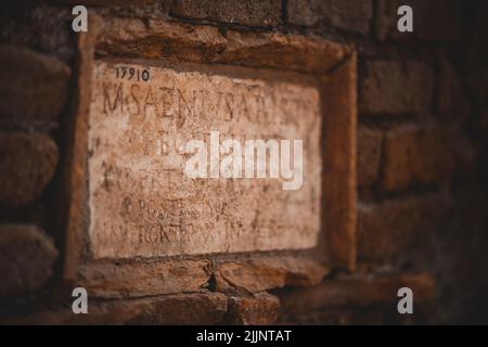 A closeup shot of ancient inscriptions engraved on a wall made of red bricks Stock Photo