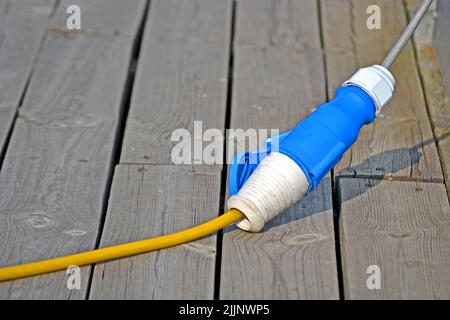 power cable waterproof connector on vintage wooden surface, modern electric tools diversity Stock Photo