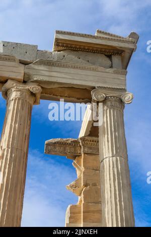 Looking up at detail of reconstructed columns on the Parthenon on the Accropolis in Athens Greece with beautiful blue sky with clouds behind Stock Photo